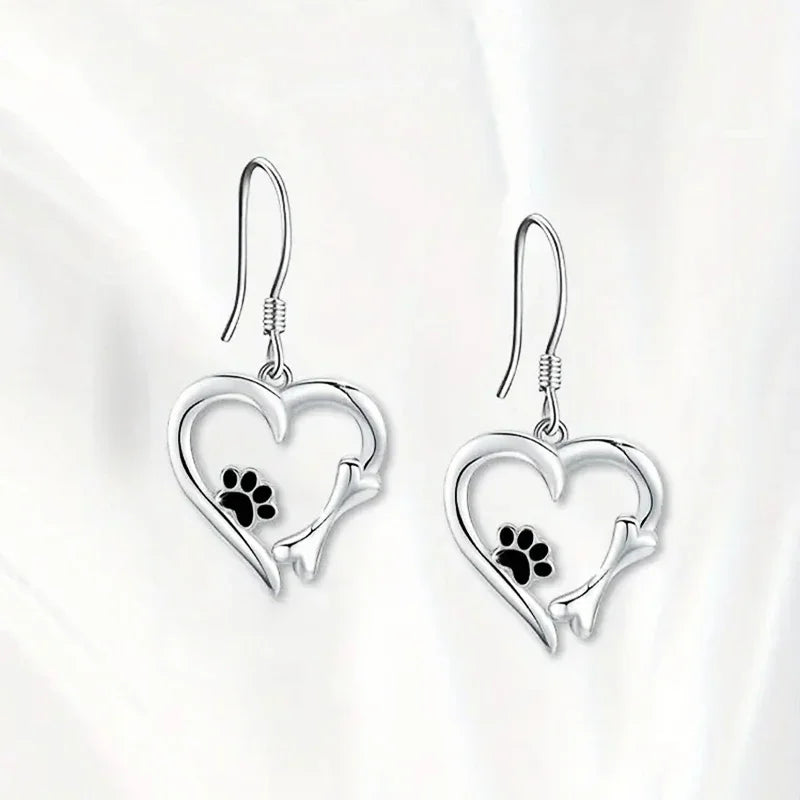 Silver dangling earrings with a heart and paw print design
