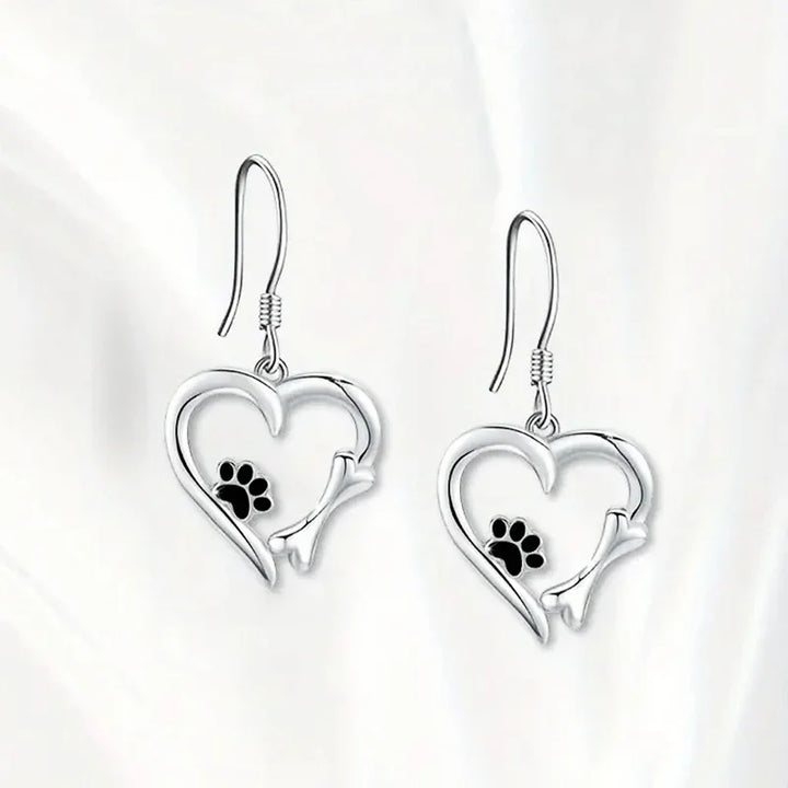 Silver dangling earrings with a heart and paw print design